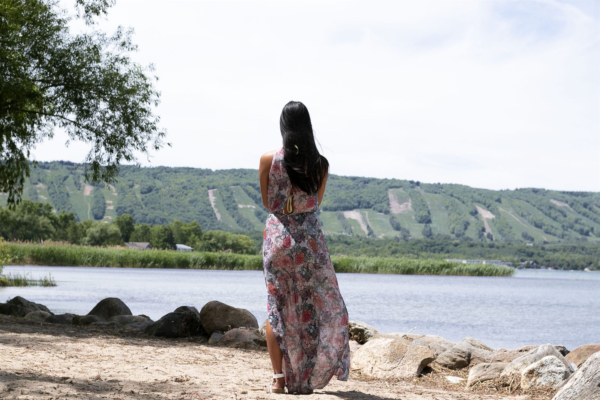 A guest on the private beach looking across Georgian Bay toward the green summer ski runs of Blue Mountain